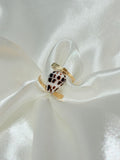 Hebrew cone shell ring with natural spotted pattern wrapped onto a gold band with gold wire