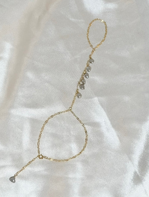 Keshi pearl hand chain bracelet with seven gray pearls along delicate gold paperclip chain draping