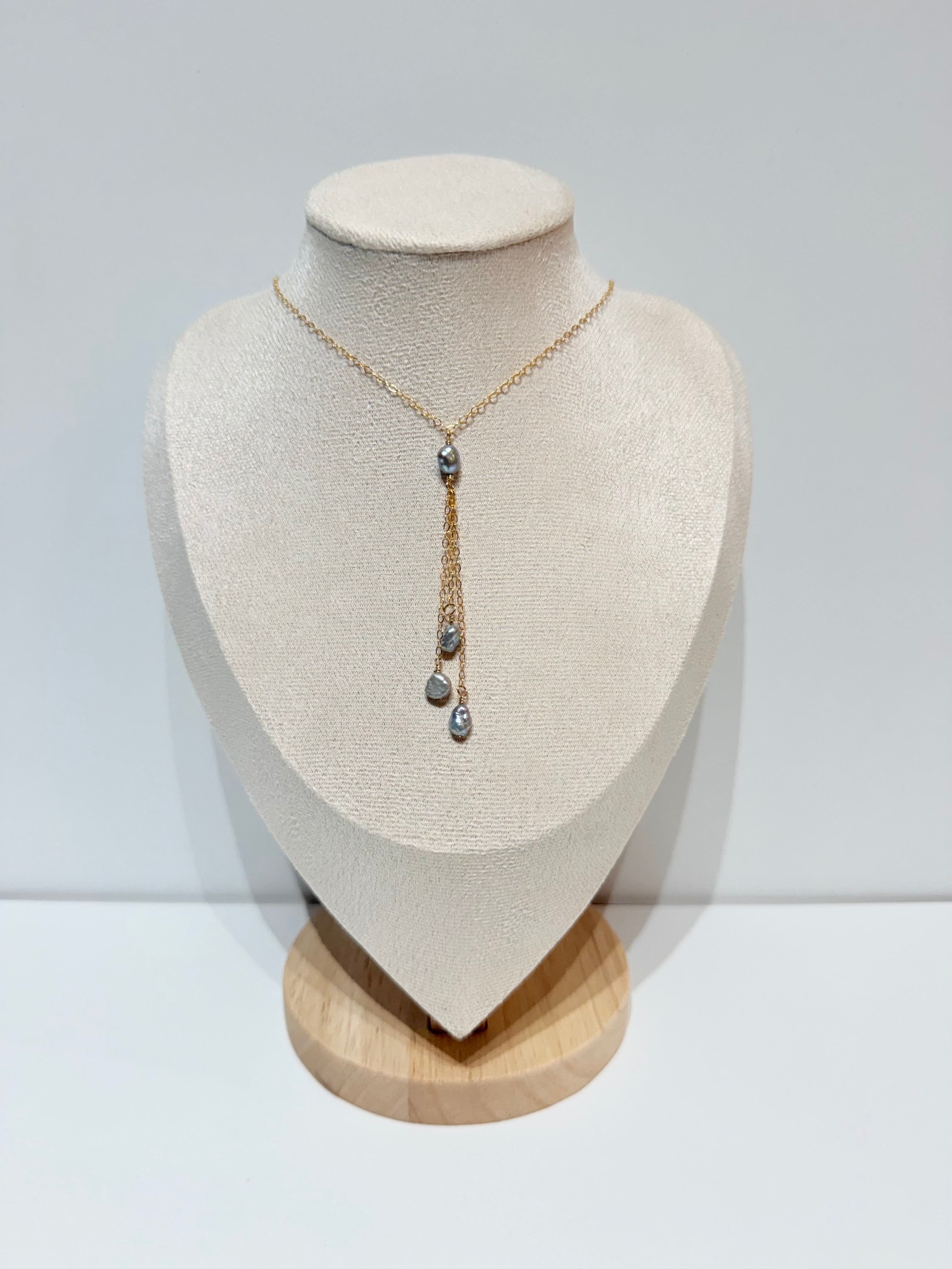 Mahina Y-drop necklace with one gray keshi pearl at center and three pearls cascading below on delicate gold chain tassels